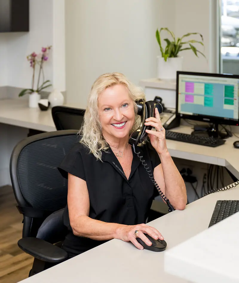 The receptionist at Downtown Dental Design in Austin TX answering the phone